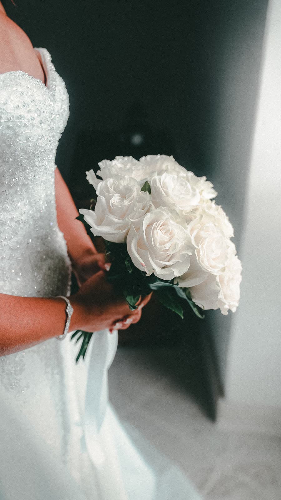 Le bouquet de roses blanches contre la robe