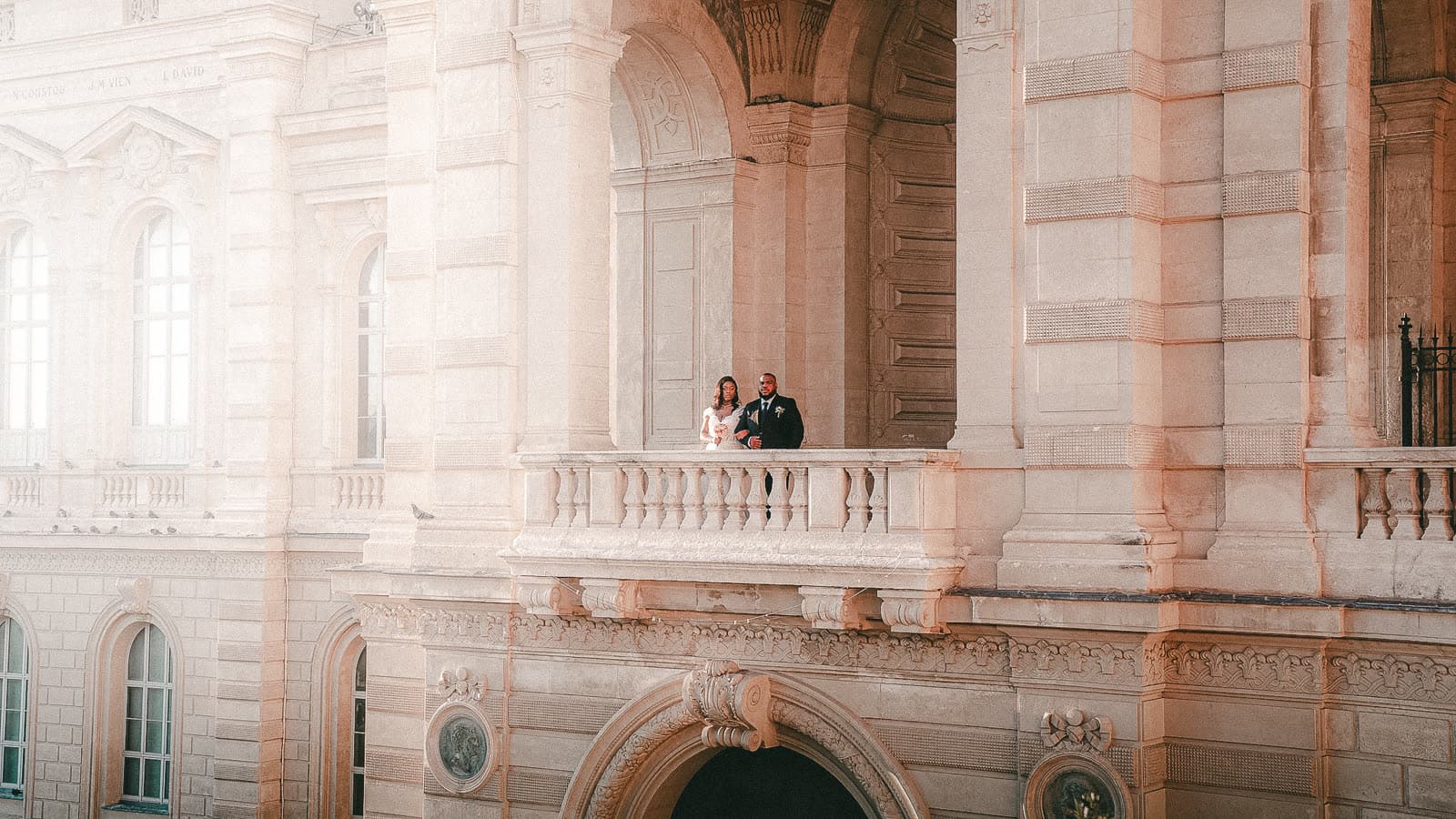 Les mariés sur le balcon du palais, minuscules dans l’architecture
