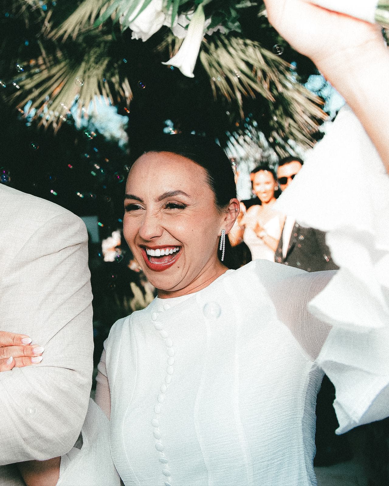 La mariée éclate de rire à la sortie, les confettis en l’air